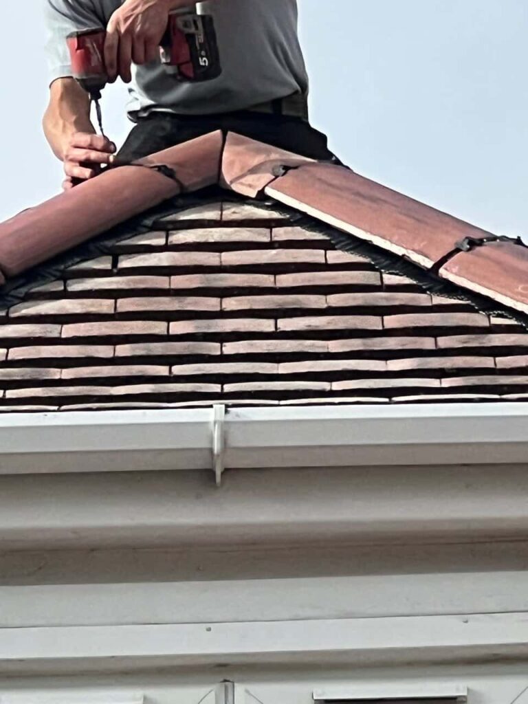 This is a photo of one of the operatives of MCM Roofing Repairs Lymington installing new ridge tiles